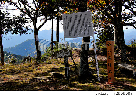 丹波市にある金山城跡の頂上の金山城跡本丸、金山城本丸跡を示す頂上標と金山城物語の説明看板 72909985