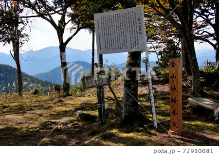 丹波市にある金山城跡の頂上の金山城跡本丸、金山城本丸跡を示す頂上標と金山城物語の説明看板　別アングル 72910081
