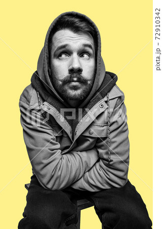 Half-length portrait of young man isolated over yellow background. 72910342
