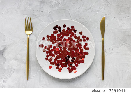 Gold cutlery, plate with hearts, gray background Gold cutlery, plate with hearts, gray background 72910414