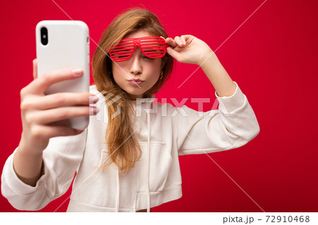 Closeup portrait of attractive positive smiling young blonde woman wearing stylish white hoodie and Closeup portrait of attractive positive smiling young blonde woman wearing stylish white hoodie and 72910468