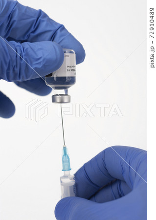 Close up human fingers in gloves, holding covid-19 vaccine vial and syringe with needle. Medical concept. Close up human fingers in gloves, holding covid-19 vaccine vial and syringe with needle. Medical concept. 72910489