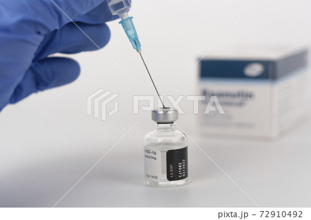 Close up human fingers in gloves, holding syringe with needle and covid-19 vaccine vial. Medical concept. Close up human fingers in gloves, holding syringe with needle and covid-19 vaccine vial. Medical concept. 72910492