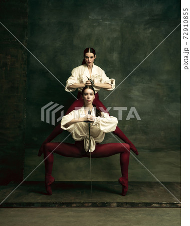 Two young female ballet dancers like duelists with swords. Ballet and contemporary choreography concept. Creative art photo. 72910855