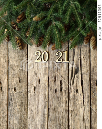 2021 New Year.Christmas greeting background for postcards, web pages and greetings.Fir branches on a wooden ancient background with place for text. 72911398