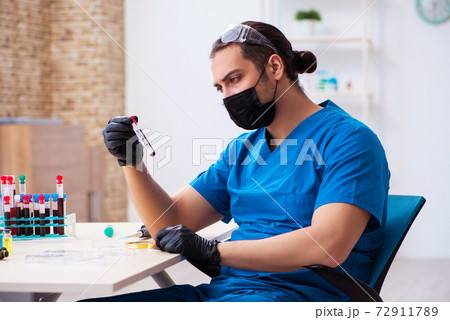 Young male biochemist testing blood samples Young male biochemist testing blood samples 72911789