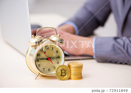 Young man earning money via Internet in time management concept Young man earning money via Internet in time management concept 72911849