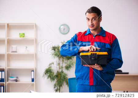 Young male contractor repairing furniture in the office 72912825
