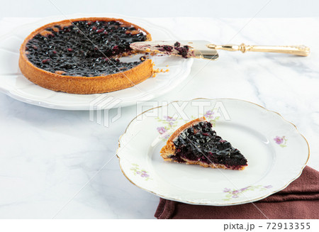 Cut blueberry tart with a cake slice 72913355