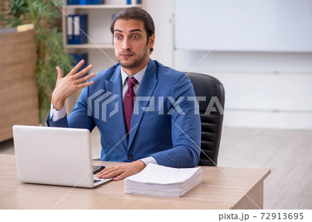 Young male employee sitting in the office in front of whiteboard 72913695