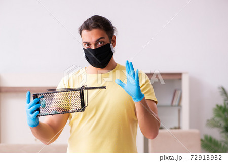 Young man and mousetrap at home 72913932