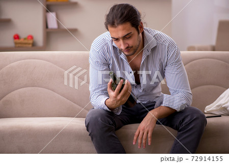 Young drunk man suffering at home 72914155