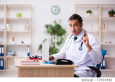 Young male doctor in telemedicine concept 72914482