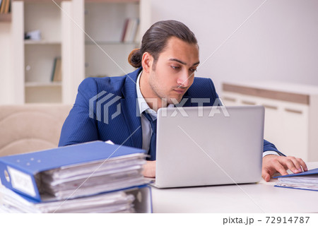Young male employee working from home in pandemic concept 72914787