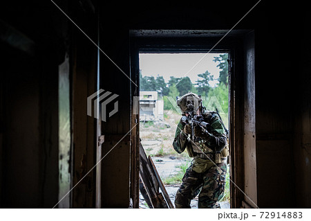 Soldier in full US MARSOC equipment entering abandoned building, aiming different angles with MK18 assault rifle 72914883