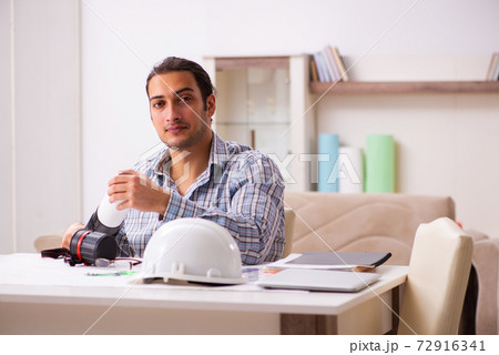 Young male architect working from house during pandemic 72916341