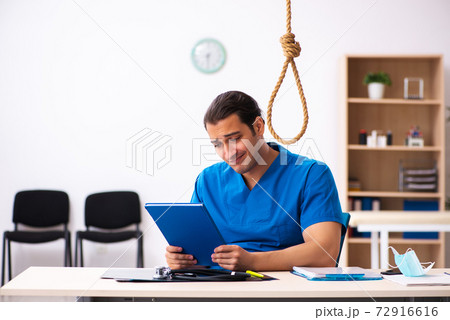 Young male doctor committing suicide at workplace Young male doctor committing suicide at workplace 72916616