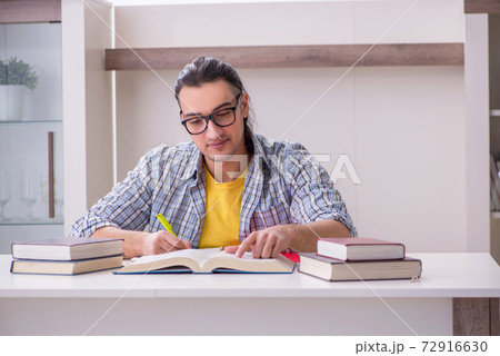Young male student preparing for exam at home Young male student preparing for exam at home 72916630
