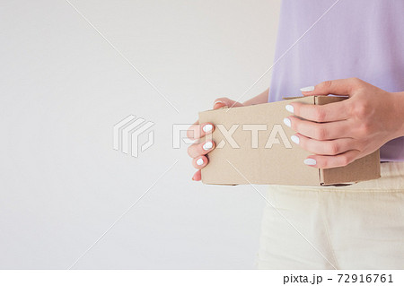 Сourier delivered the package and hands it over to the recipient. Cardboard box with parcel in the hands of a satisfied recipient. Concept of delivery time of goods, fast delivery 72916761