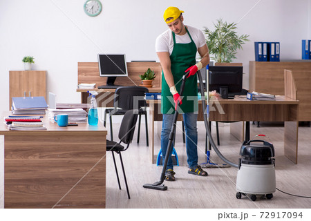 Young male contractor cleaning the office Young male contractor cleaning the office 72917094