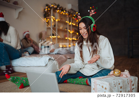 Female with antlers while speaking with online friend on laptop 72917305