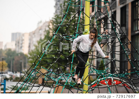 Young woman having fun on the rope pyramid 72917697