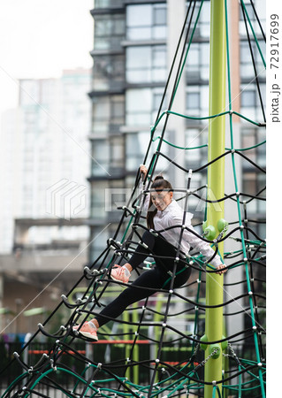 Young woman having fun on the rope pyramid Young woman having fun on the rope pyramid 72917699