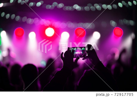 Person close up of recording video with smartphone during a concert. Person close up of recording video with smartphone during a concert. 72917705