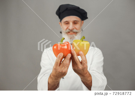 Chef in white uniform over gray background Chef in white uniform over gray background 72918772