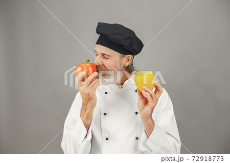 Chef in white uniform over gray background Chef in white uniform over gray background 72918773