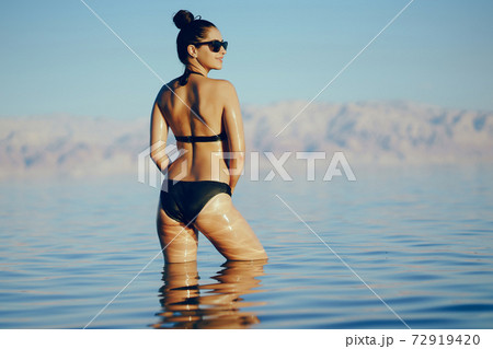 brunette girl swimming in the dead sea brunette girl swimming in the dead sea 72919420