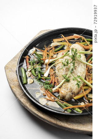 chinese style steamed fish fillet with vegetables on hot plate 72919937