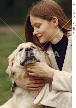 Woman walks in autumn forest with a dog 72920391