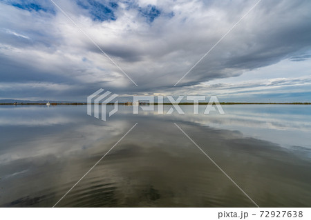 Flooded rice fields under cloudy sky reflection 72927638