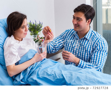 Caring loving husband visiting pregnant wife in hospital 72927728