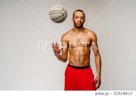 Muscular african american sportsman playing basketball shitless over light grey background Muscular african american sportsman playing basketball shitless over light grey background 72928617