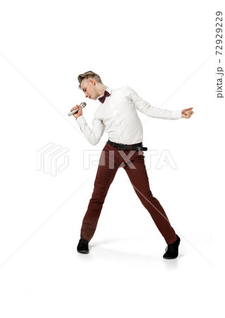 Happy young man dancing in casual clothes or suit, remaking legendary moves of celebrity from culture history 72929229
