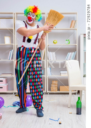 Funny clown doing cleaning at home 72929784