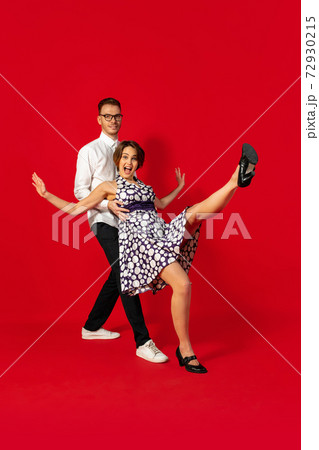 Old-school fashioned young couple dancing isolated on red background Old-school fashioned young couple dancing isolated on red background 72930215