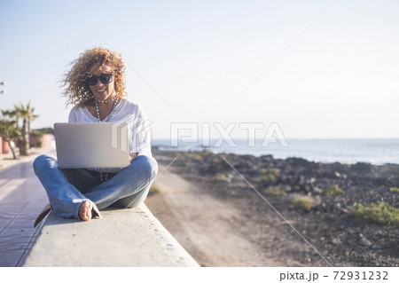 Happy lifestyle digital nomad young cheerful woman work outdoor with laptop computer - people and modern technology job and communication related - alternative office at the beach Happy lifestyle digital nomad young cheerful woman work outdoor with laptop computer - people and modern technology job and communication related - alternative office at the beach 72931232