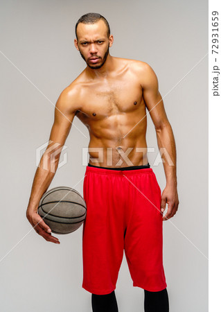 Muscular african american sportsman playing basketball shitless over light grey background 72931659