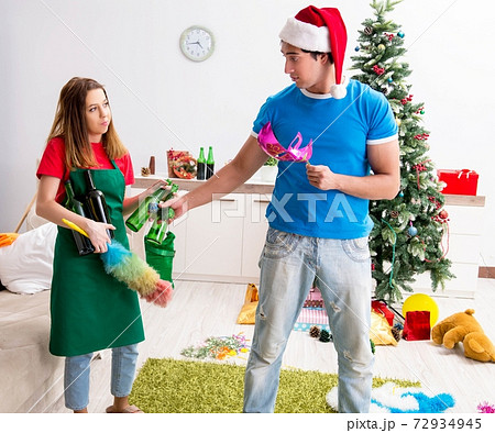 Young family cleaning apartment after christmas party 72934945