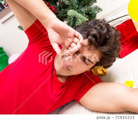 Young man drunk at home after christmas party Young man drunk at home after christmas party 72935233