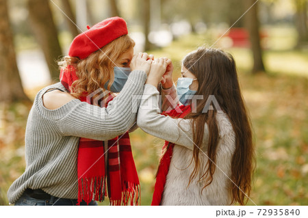 Mother with daughter walks outside in masks 72935840