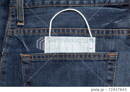 Protective face mask lying in back pocket of jeans Protective face mask lying in back pocket of jeans 72937643