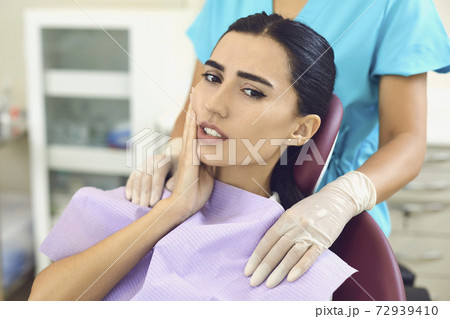 Woman patient feeling toothache touching cheek in dental clinic Woman patient feeling toothache touching cheek in dental clinic 72939410