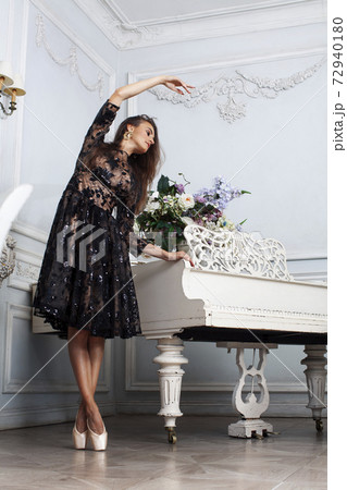 young pretty brunette ballet dancer at piano in luxury royal interior, lifestyle rich people concept 72940180