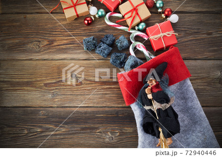 The Befana with sweet coal and candy on wooden background. Italian Epiphany day tradition. 72940446