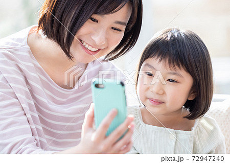 ファミリー スマホを見るママと女の子 ファミリー スマホを見るママと女の子 72947240