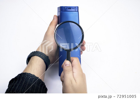 Chemical components on the shampoo label. A hand holds a blue jar and a magnifier, where the harmful ingredients of a detergent are written in close up. Place for an inscription. Chemical components on the shampoo label. A hand holds a blue jar and a magnifier, where the harmful ingredients of a detergent are written in close up. Place for an inscription. 72951005